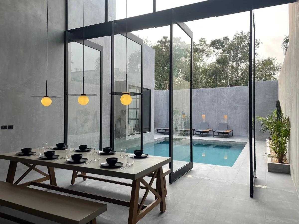 Casa Arroqueno área de alberca de lujo rodeada de exuberante vegetación de selva y arquitectura moderna