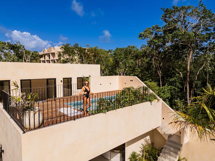 Sala luminosa Casa Dalida con grandes aberturas a la selva